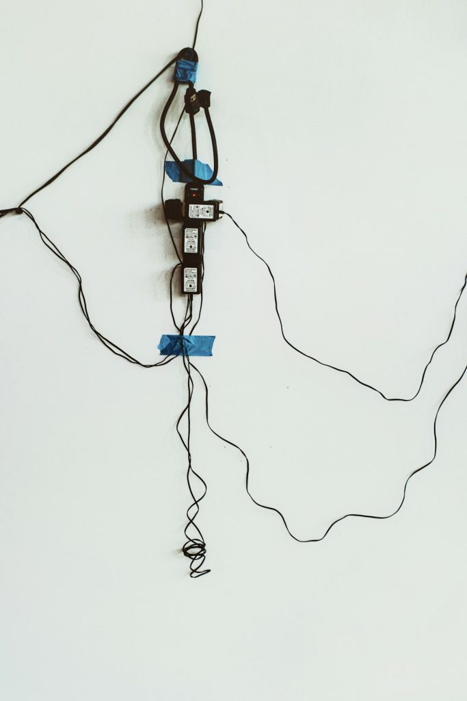 Wired #2  |  Im always looking for things that are a bit abstract or different. I was visiting an art exhibit and decided to walk around behind one of the walls that had been erected to display art — and this is what I found — an interesting twist of electrical cords that were powering the lights above the paintings. It created its own interesting form of art.